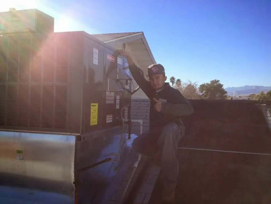 HVAC technician performing HVAC Inspection on a rooftop unit in West Loch Estate